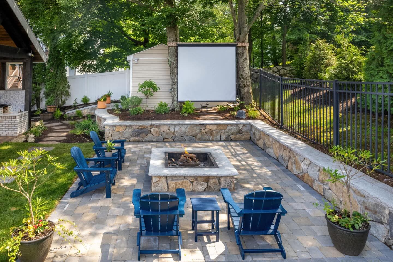 patio with stone sitting wall and fire pit in Dedham MA — M Coelho Group
