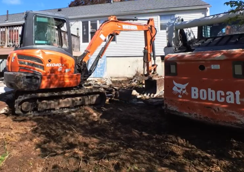 Excavating the backyard with machines to prepare for a new paver patio in Framingham Massachusetts M Coelho Group