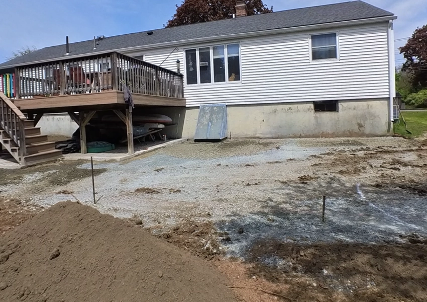 Grading the crushed stone base for a new paver patio in Framingham Massachusetts M Coelho Group