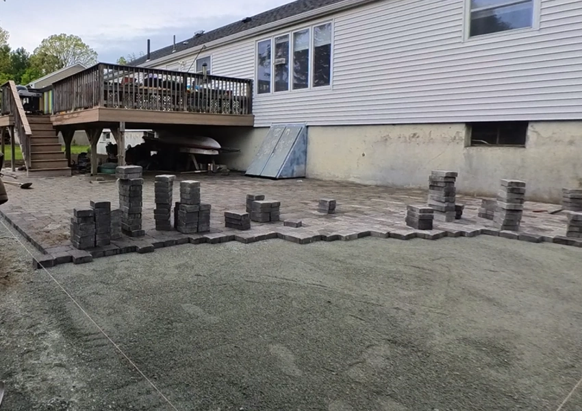 Laying the first rows of pavers on the prepared base in Framingham Massachusetts M Coelho Group
